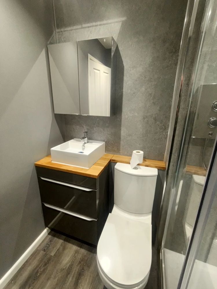 Bathroom vanity unit with basin, mirrored cabinet and shower