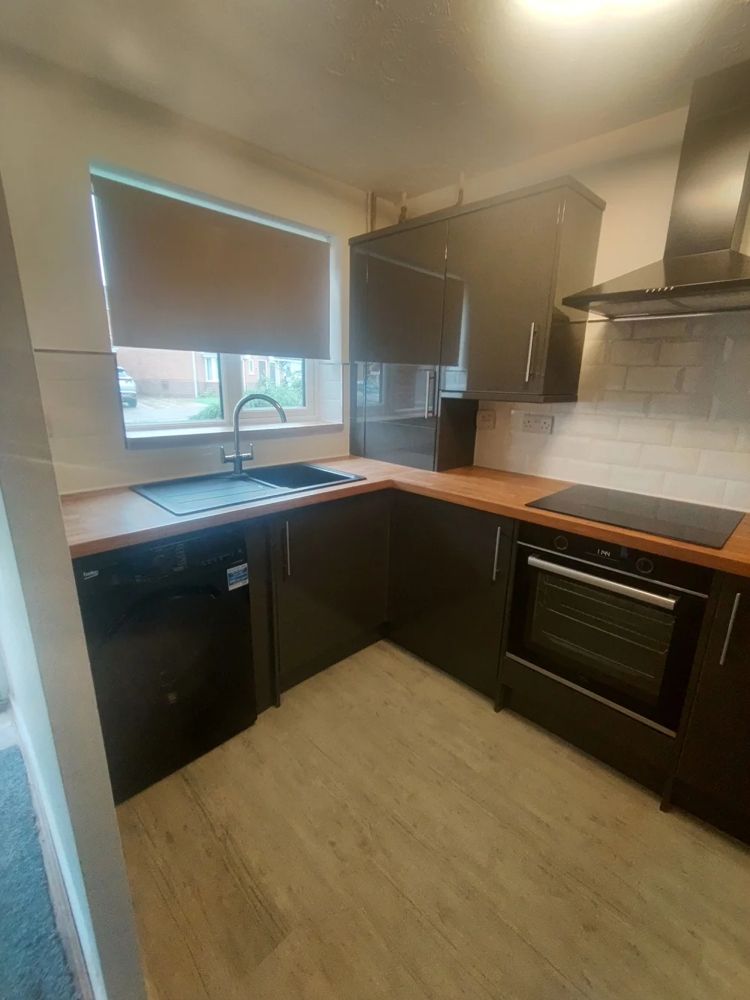 Dark gloss kitchen with oak worktop, sink and window