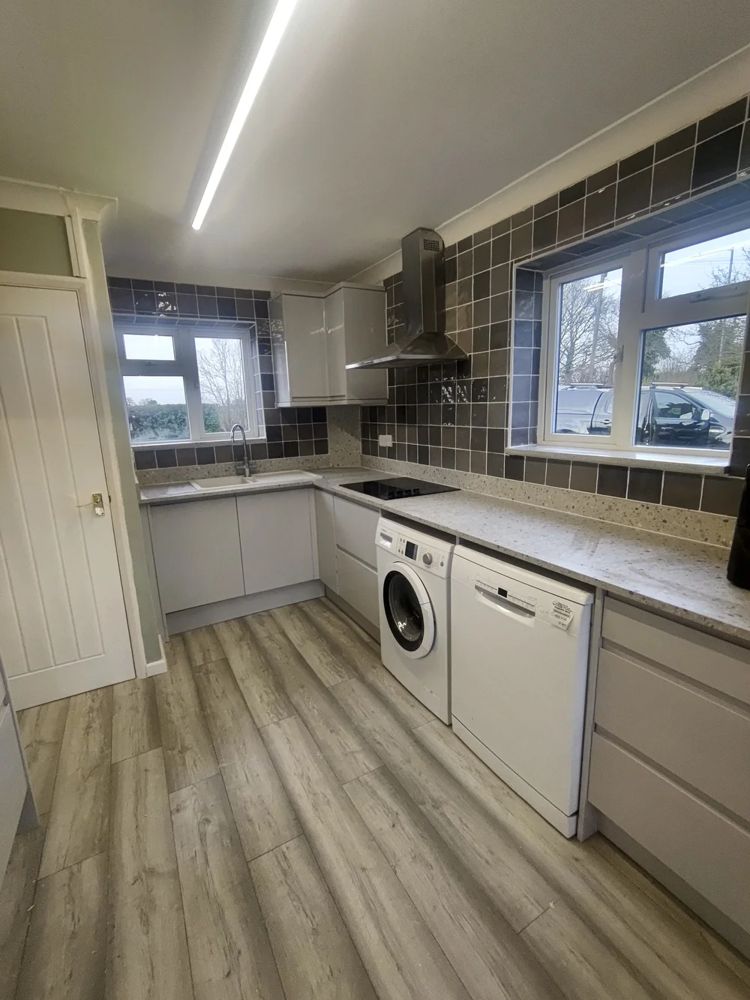 Light kitchen with grey tiled splashback and washing machine
