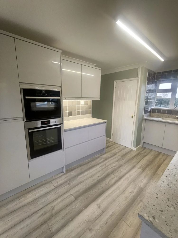 Light grey gloss kitchen with double oven tower